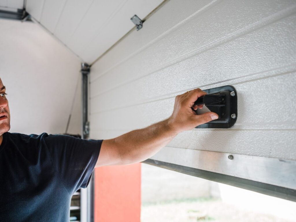 Person checking or closing a garage door by the interior handle.