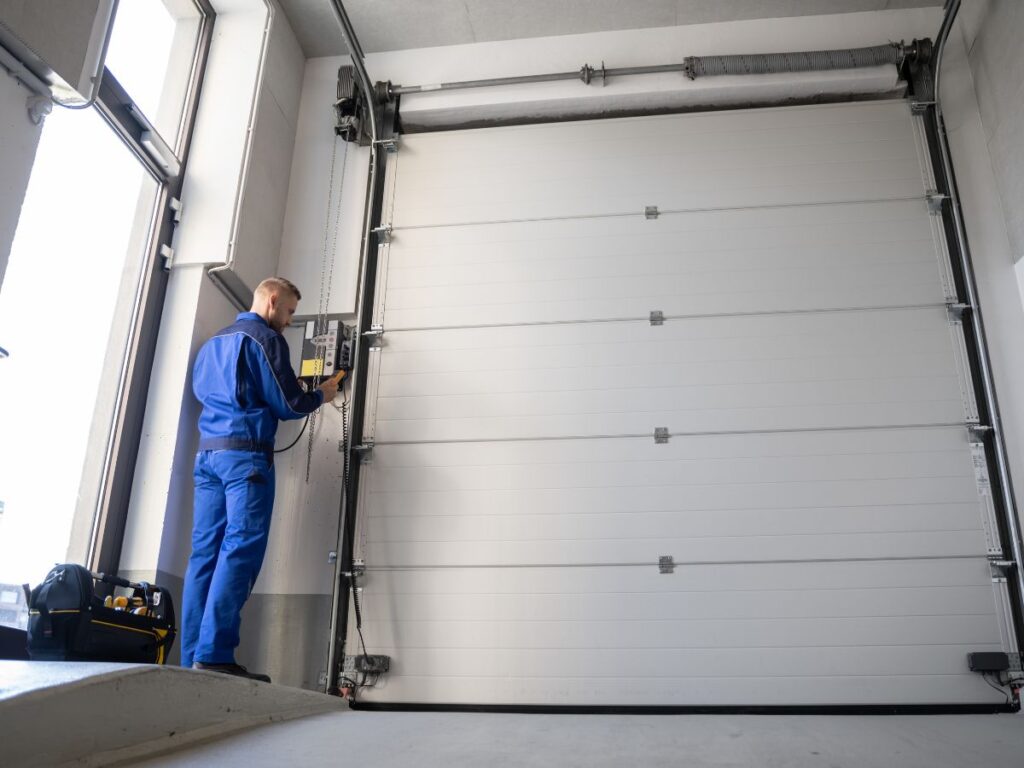 Technician testing a large commercial garage door control unit.