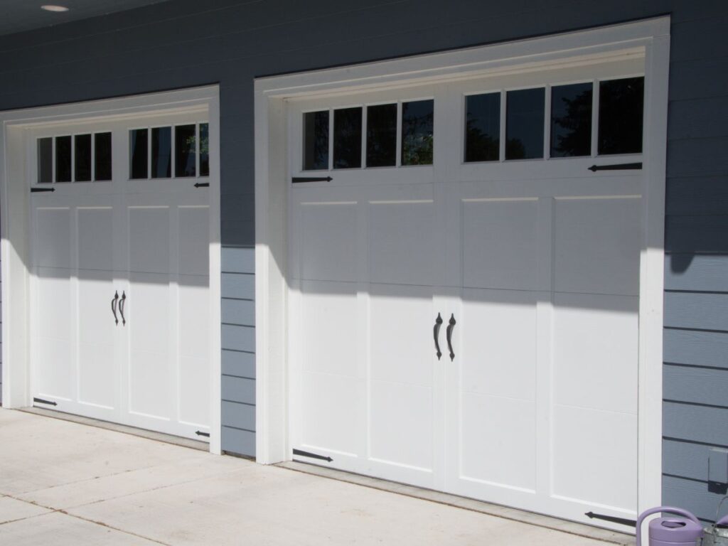 Two white carriage-style garage doors on a residential garage.