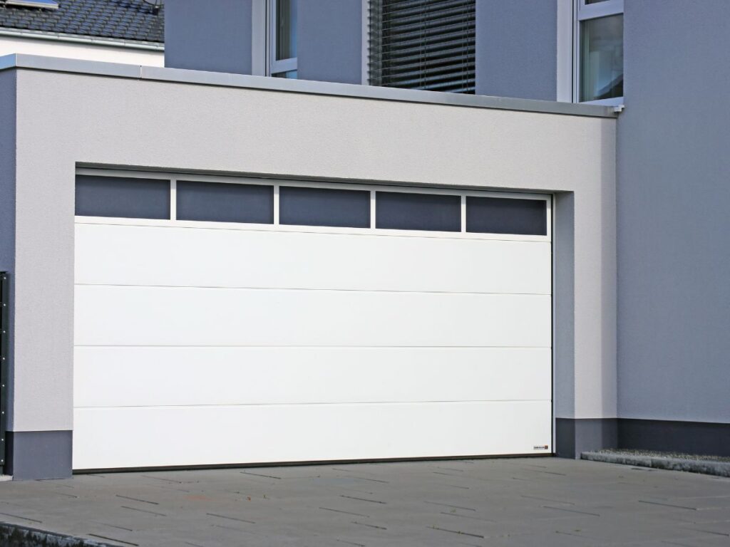Modern white garage door on a contemporary home exterior.